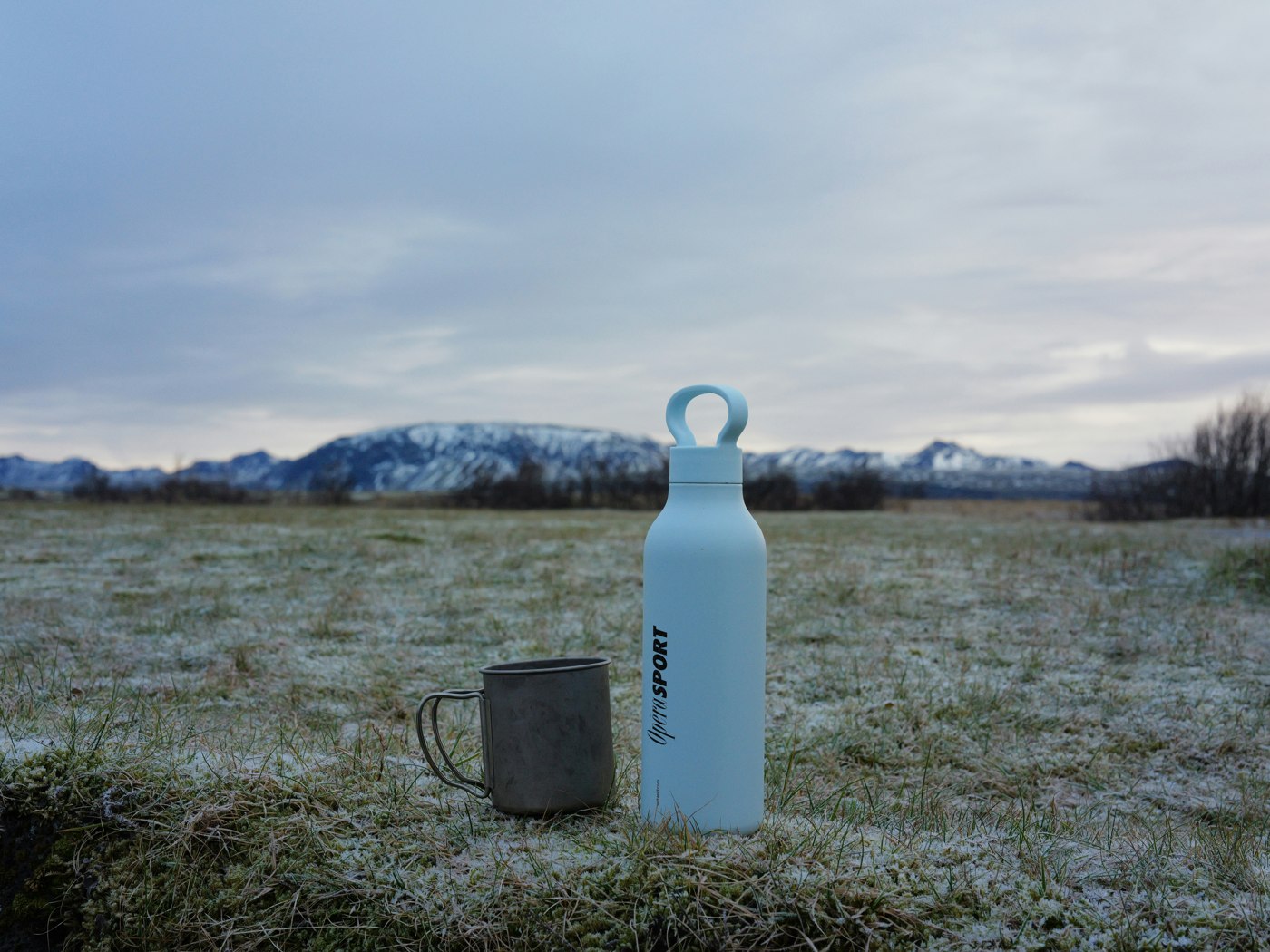 Holding a water bottle outdoors overlooking hills