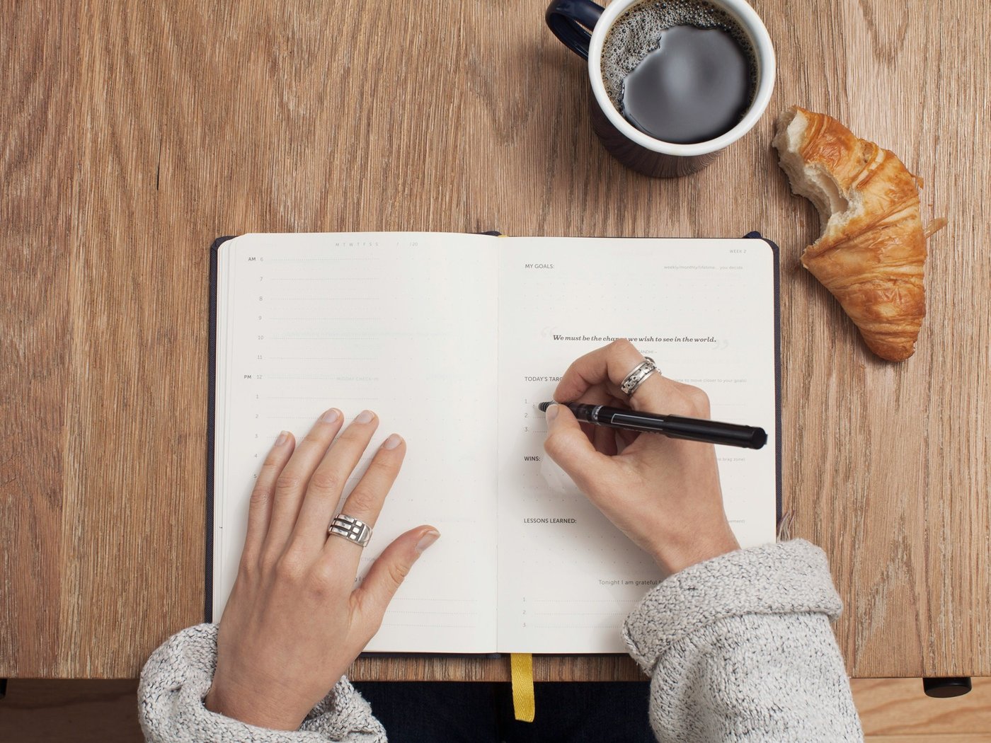 Writing notes next to a coffee cup